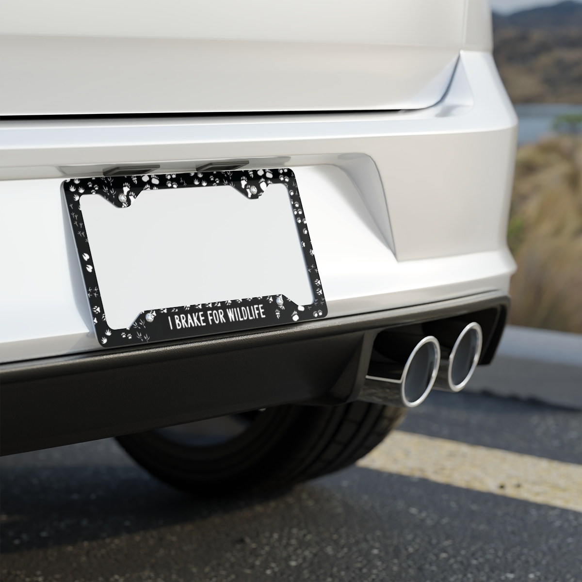 I Brake for Wildlife license plate frame with white animal paw prints on black metal frame for wildlife lovers and eco conscious drivers