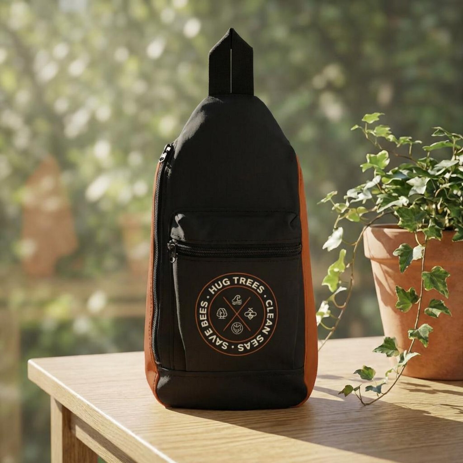 Hug Trees Clean Seas Save Bees backpack featuring circular conservation emblem with tree, wave, and bee icons on black outdoor backpack